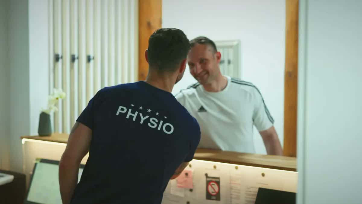 Physiotherapeut von POM MED im Gespräch mit einem Patienten am Empfang