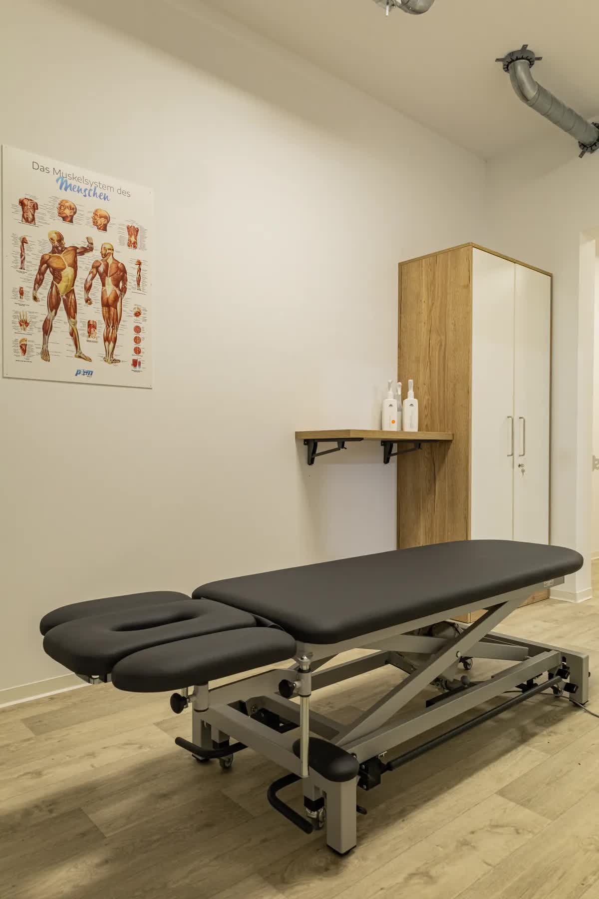 Behandlungsraum der POM MED mit Therapieliege und Anatomie-Postern