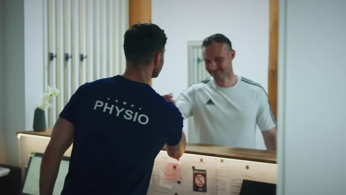 Physiotherapeut der POM MED begrüßt einen Patienten am Empfang