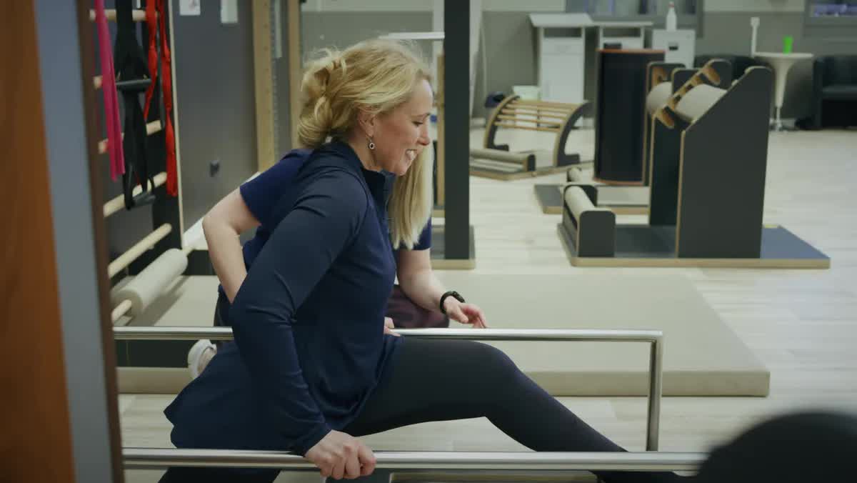Physiotherapeutin bei einer Dehnübung im Trainingsbereich